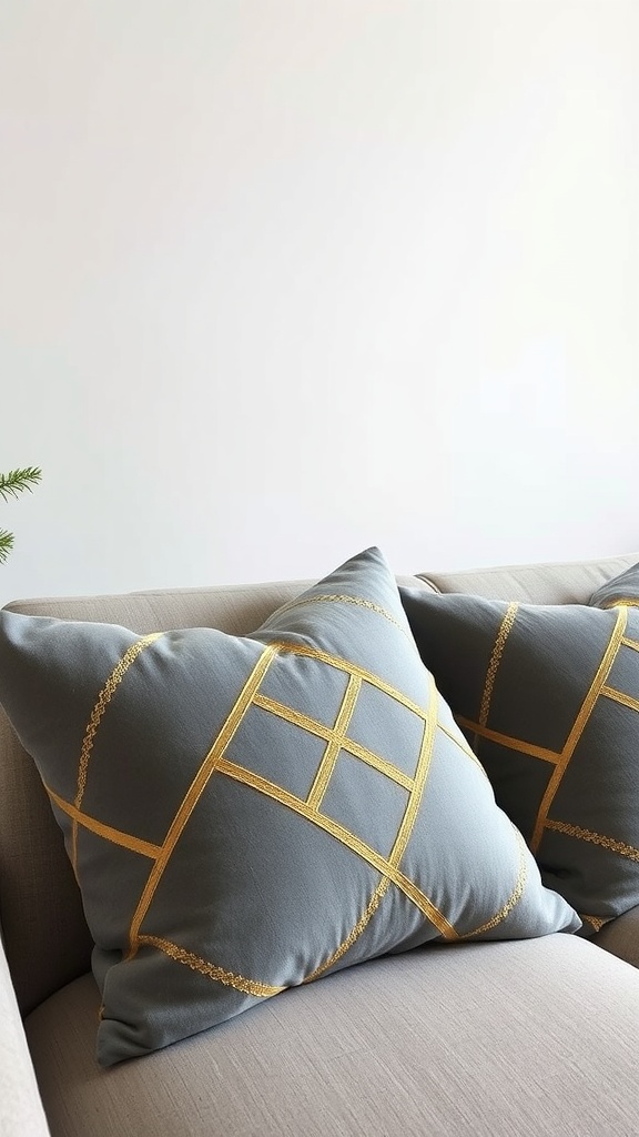 Two grey pillows with gold geometric patterns resting on a beige sofa.